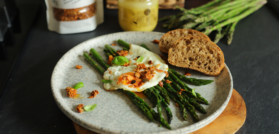 Asparagus with fried egg on ghee butter and crunchy Spicy Seeds